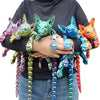 A hand holds a collection of realistic Sphynx cat fidget toys in various colors and textures.
