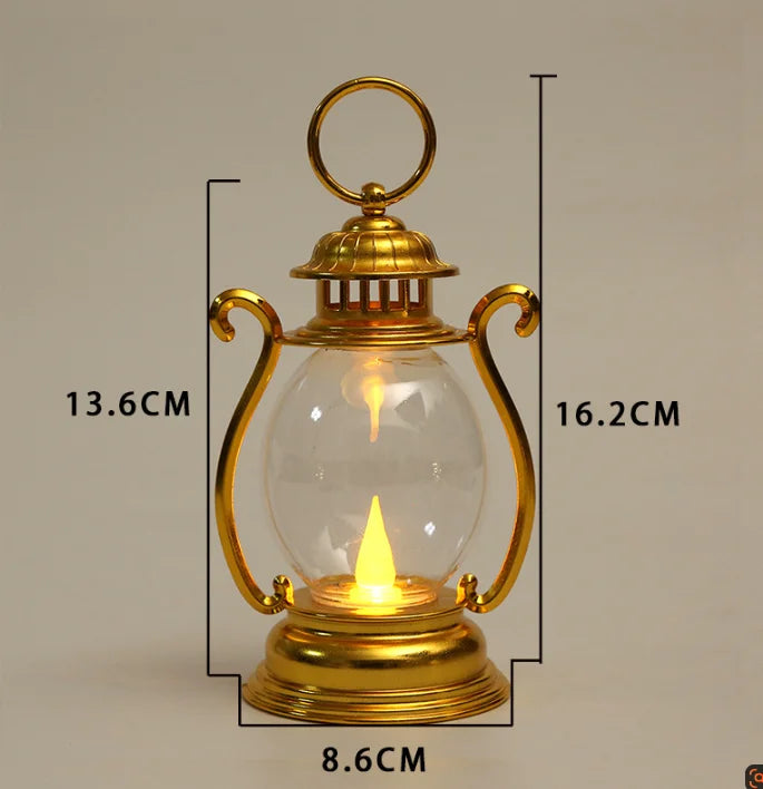 A brass retro battery-powered desk lamp with a clear glass globe and a golden finish.