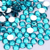 A close-up view of numerous round, flatback resin rhinestones in various shades of turquoise and clear blue.