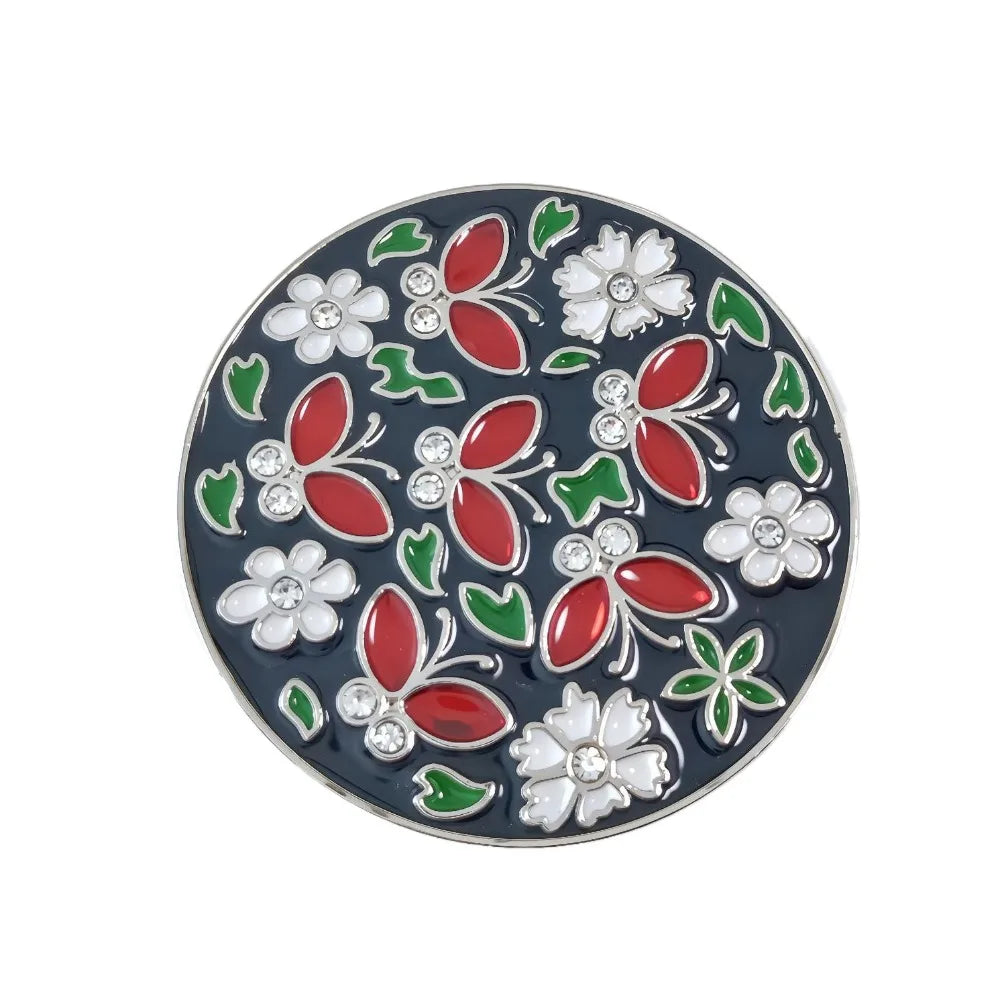 A round decorative piece featuring floral crystal designs in red, green, and white on a dark blue background.