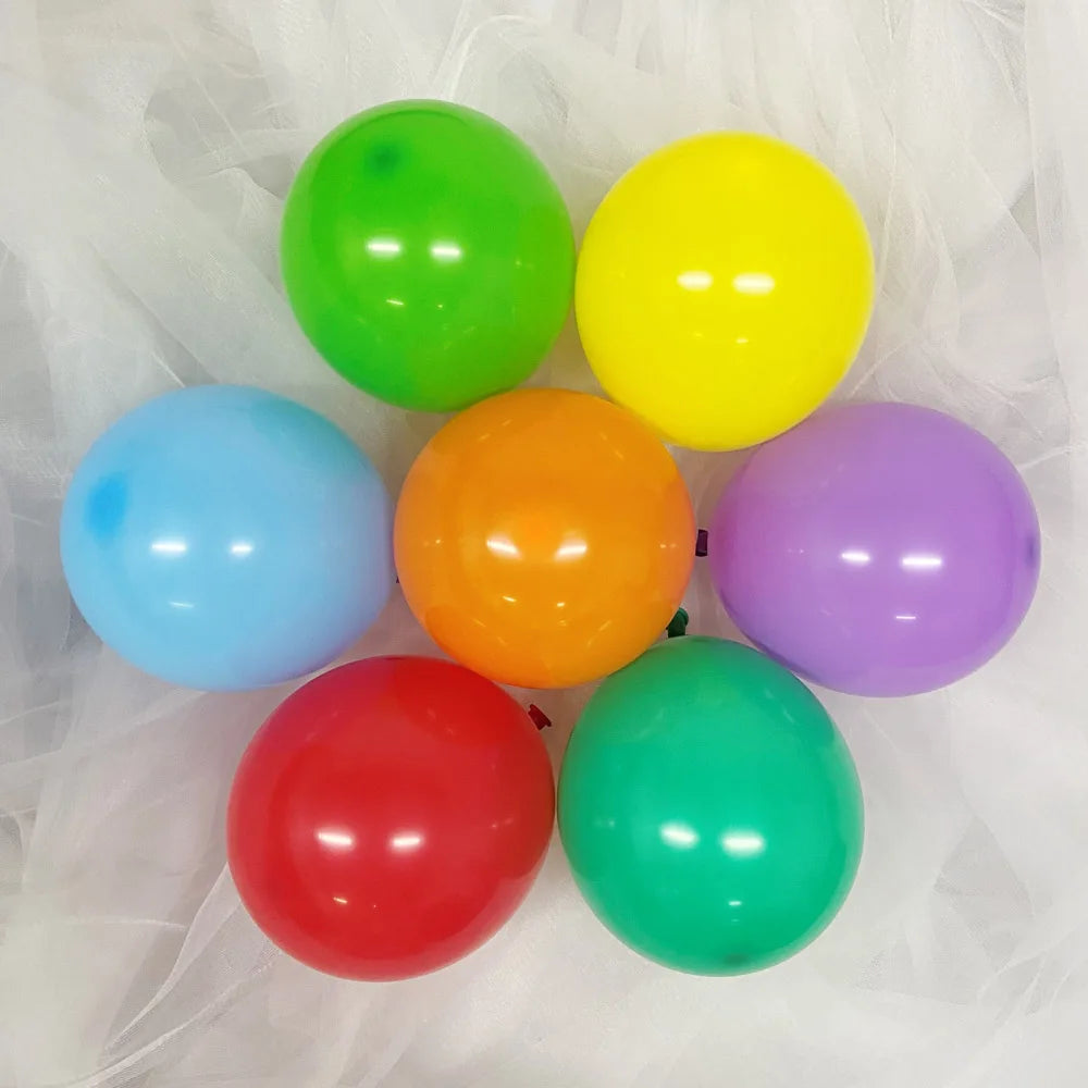 A collection of seven vibrant latex balloons in colors including green, yellow, blue, orange, purple, and red.