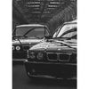 Schwarz-weißes Foto eines klassischen BMW-Wagens unter einer Metalldachkonstruktion.