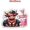 A cute brown calf charm with pink flowers and black wings, next to a pink iced drink.