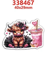 A cute brown calf charm with pink flowers and black wings, next to a pink iced drink.