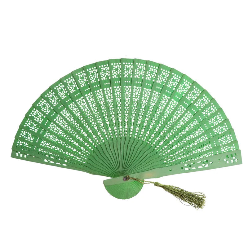 A hand carved bamboo folding fan in green, shown open and spread wide.