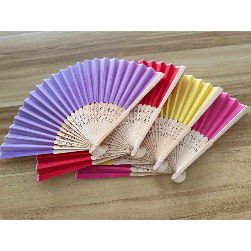 A fan of multiple colors, including purple, pink, red, and yellow, made with a bamboo frame.