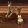 Handmade Egyptian Pharaoh dog statue in gold color resting on a wooden surface.