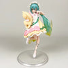 A figurine of a Gothic Lolita Miku action fairy doll with teal hair, pink and yellow outfit, and a wide-brimmed hat.
