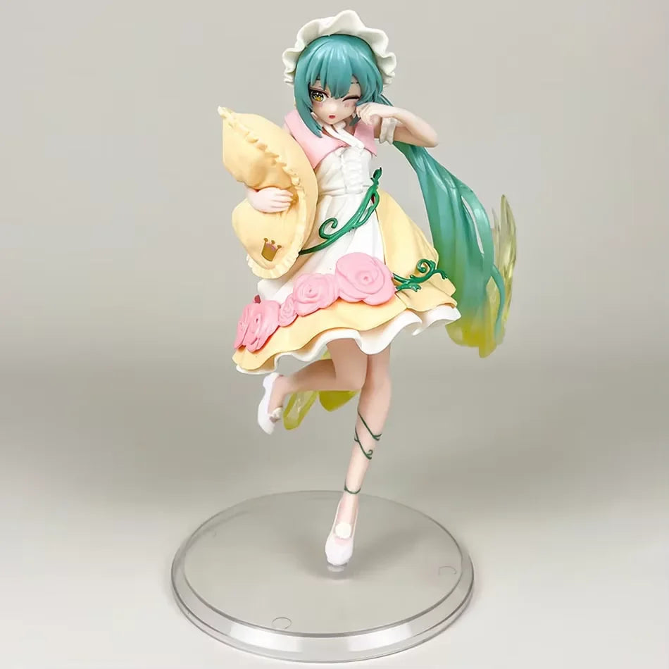 A figurine of a Gothic Lolita Miku action fairy doll with teal hair, pink and yellow outfit, and a wide-brimmed hat.
