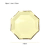 A gold disposable party tableware set featuring a yellow hexagonal plate with a gold rim.