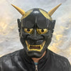 A full face Japanese Hannya demon mask with horns and fierce facial features, worn by a person.