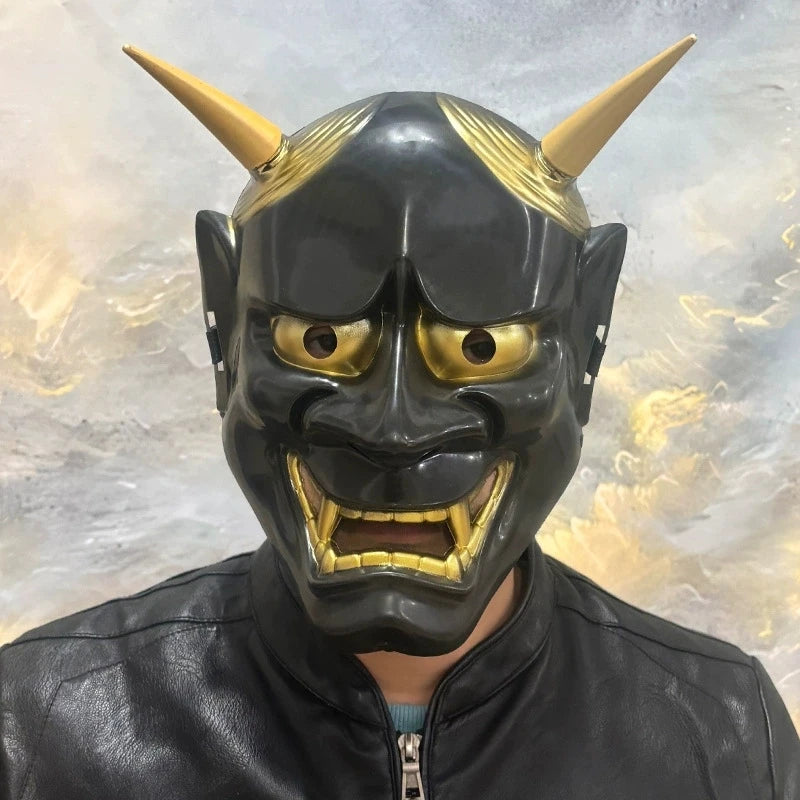 A full face Japanese Hannya demon mask with horns and fierce facial features, worn by a person.