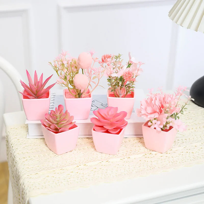 A set of six pink potted artificial plants featuring succulents and pink flowers displayed on a white surface.
