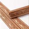 Close-up of brown self-adhesive foam wall trim strips with embossed leaf patterns.