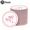 A stack of 30 pink and white checkered paper plates decorated with pink bows for a birthday party.