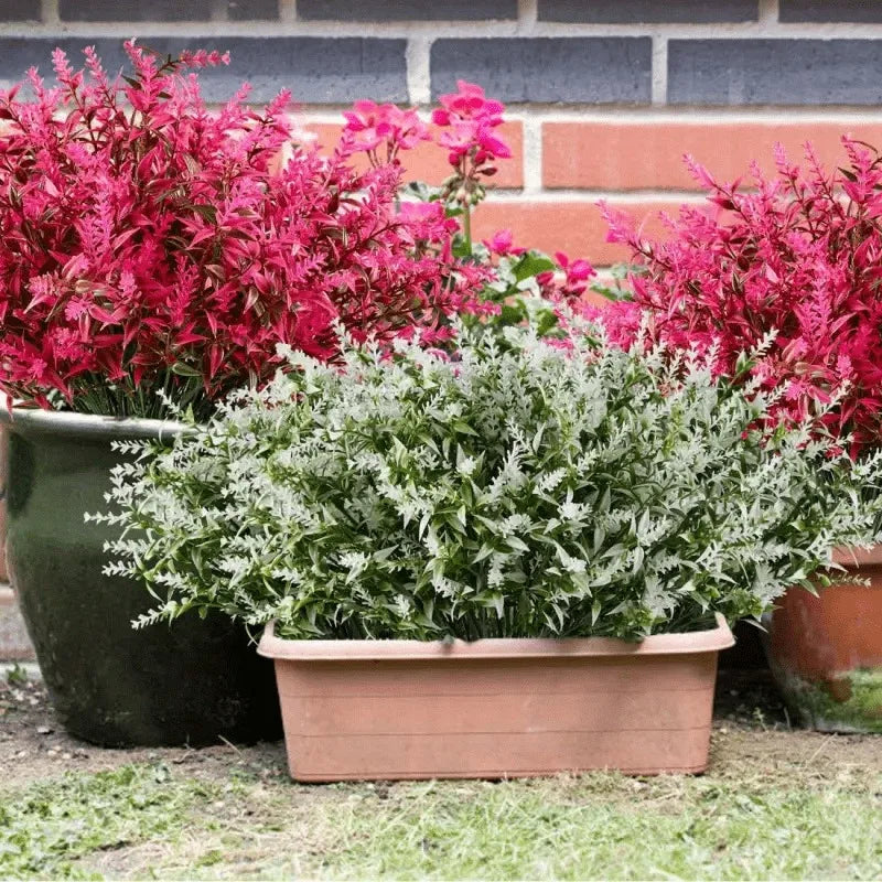 A potted artificial flower bouquet featuring vibrant pink and magenta foliage in a terracotta planter.