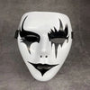 A white masquerade mask with black, flame-like facial markings and a stylized, elongated shape.