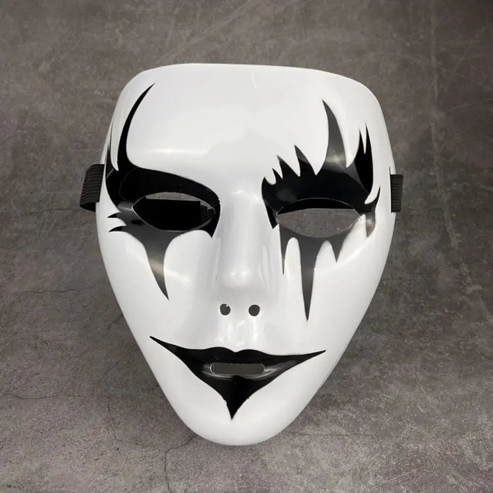 A white masquerade mask with black, flame-like facial markings and a stylized, elongated shape.