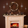 A mantelpiece decorated with a wreath, candles, and metal star wall art on a dark brown wall.
