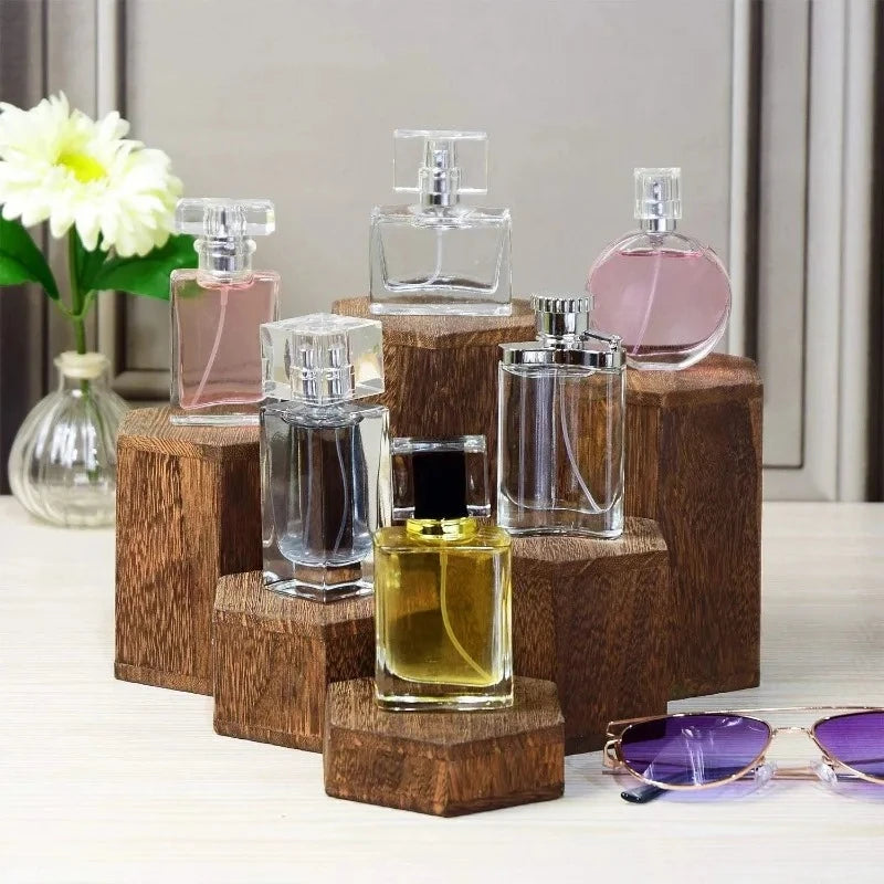 A collection of glass perfume bottles displayed on a wooden hexagonal rack.
