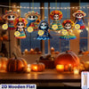 A display of flat wooden skull ornaments with colorful fabric details hanging against a blurred background.