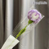 A handmade crochet tulip bouquet featuring a purple flower with a white center, packaged in clear plastic.