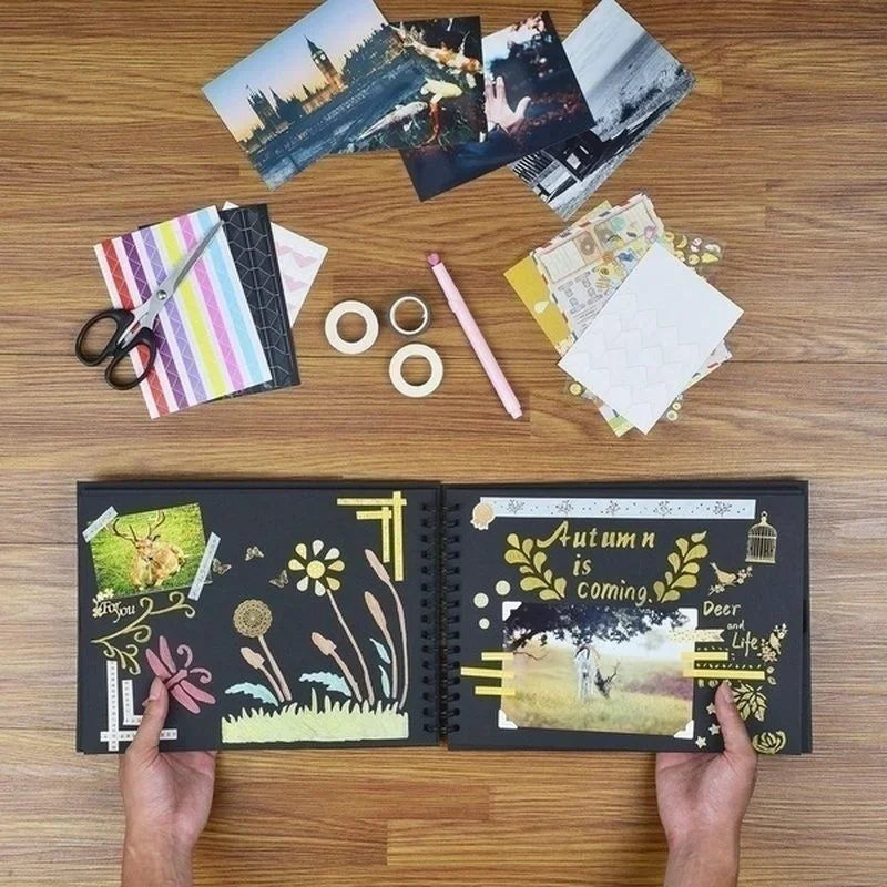 A DIY scrapbook photo album open on a wooden table with various craft supplies and photos scattered around.