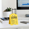 Yellow desk sign listing sarcastic answer desk rates for answers, correct answers, and dumb looks.