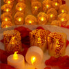 A close-up of numerous glowing orange and yellow paper lampshade tea light candles arranged on a plate with red fruit.