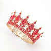 A detailed gold-toned crystal rhinestone crown featuring red gemstones used as a cake topper.