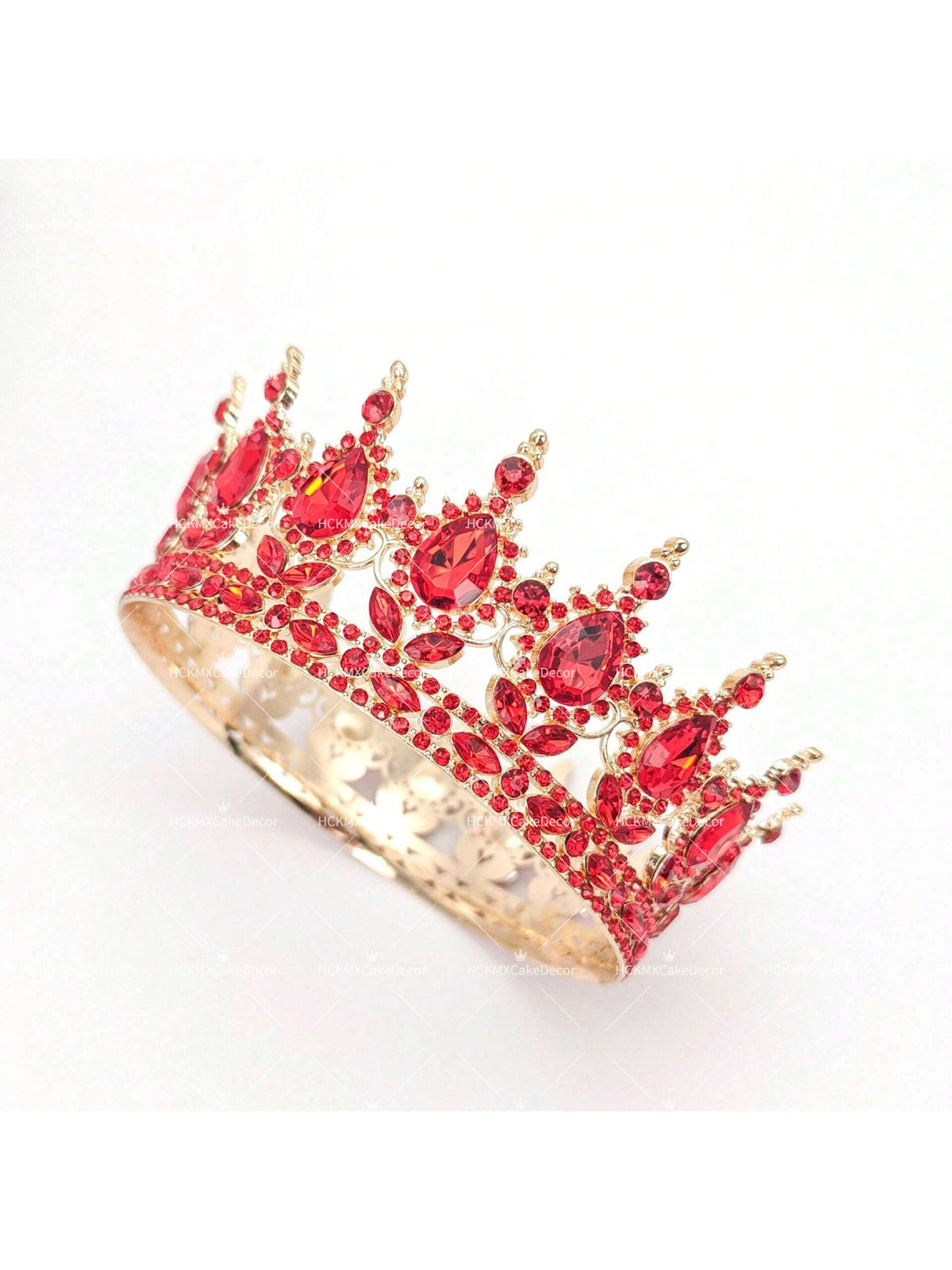 A detailed gold-toned crystal rhinestone crown featuring red gemstones used as a cake topper.