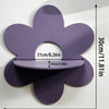A purple cherry-shaped wooden wall shelf with a cutout for display, mounted on a white wall.