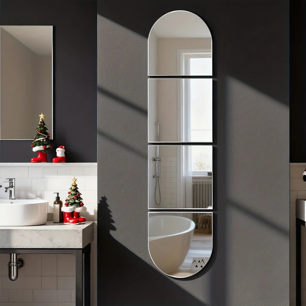 A vertical oval mirror reflects a bathroom interior, showing a sink and shower area on a dark gray wall.