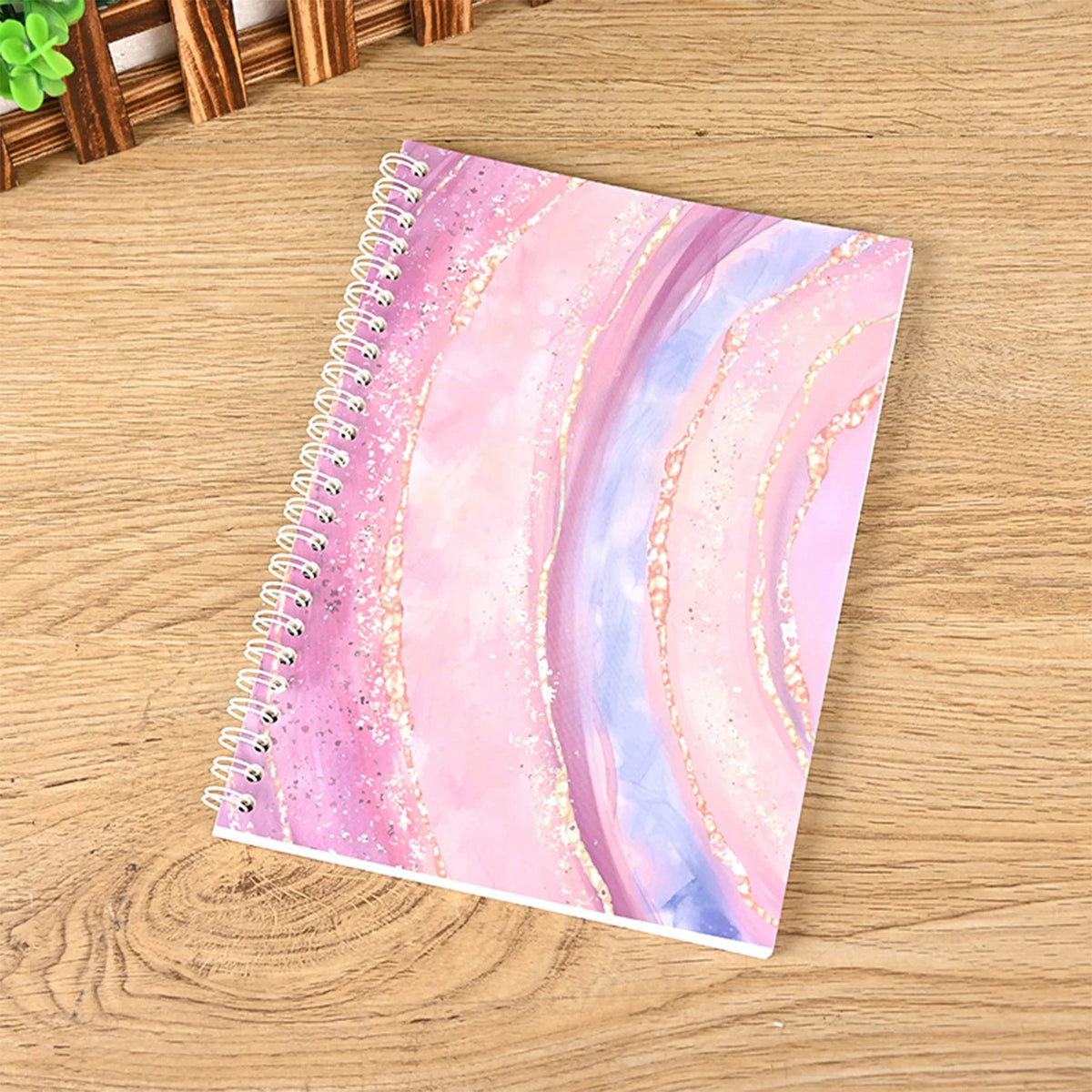 A colorful reusable sticker collecting album with a watercolor gradient design on a wooden surface.