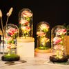 LED Galaxy rose artificial flower displayed in glass domes on a white marble surface.