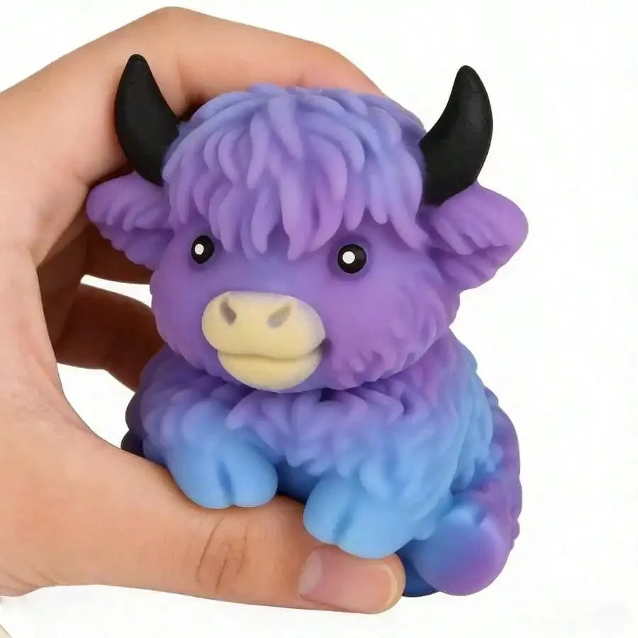 A purple and blue Scottish Highland cow squishy stress relief toy held in a hand.