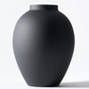 A large matte black decorative vase with a smooth, rounded shape.