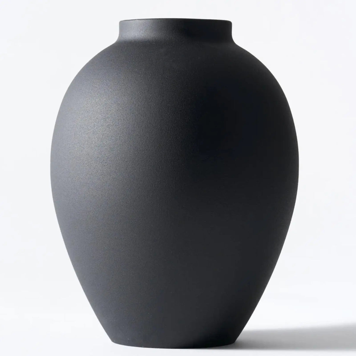 A large matte black decorative vase with a smooth, rounded shape.