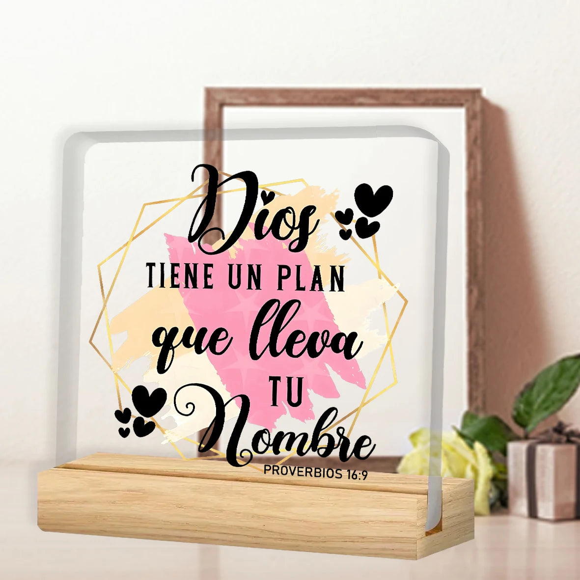A framed print featuring the Spanish phrase Dios tiene un plan que lleva tu nombre in elegant script on a white background