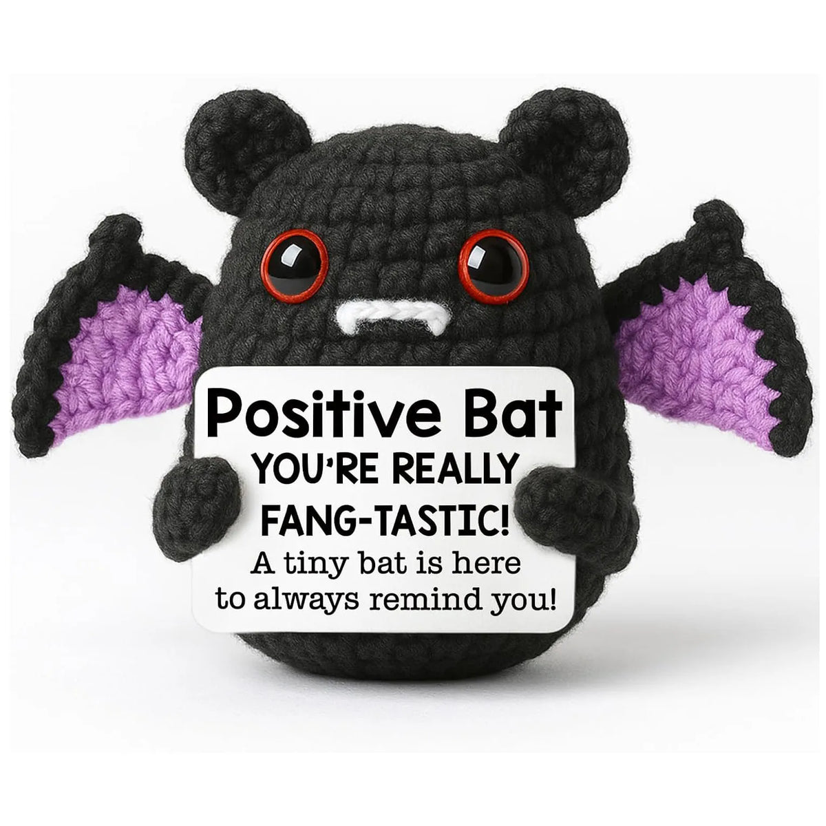 A handmade crochet bat ornament with black fur and purple accents, featuring large red eyes.