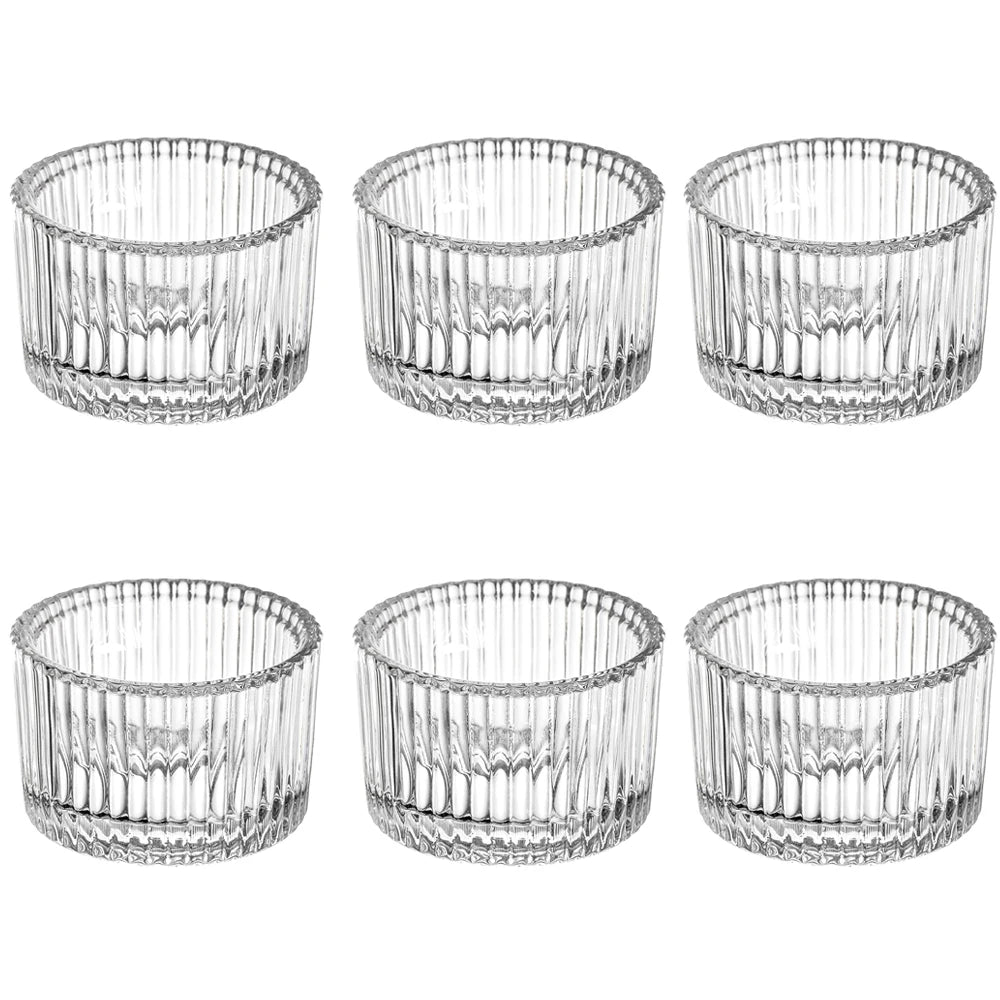 A set of nine clear glass tealight candle holders with decorative fluted patterns.