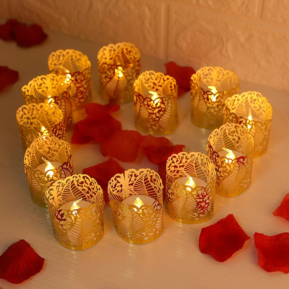 A collection of golden paper lampshade tea light candles are arranged on a white surface with red petals.