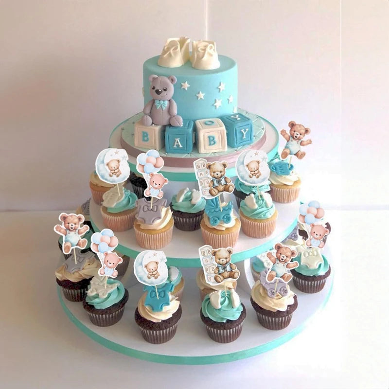 A tiered cake display featuring cupcakes with cartoon bear toppers for a baby shower or birthday party.