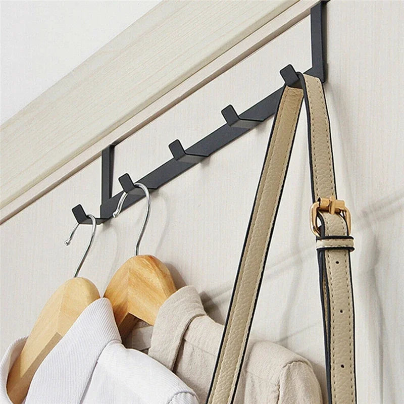 A wooden and metal 5-hook iron door and wall organizer rack mounted on a white surface.