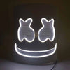 A glowing neon LED party mask shaped like a smiling face illuminates the surrounding area.