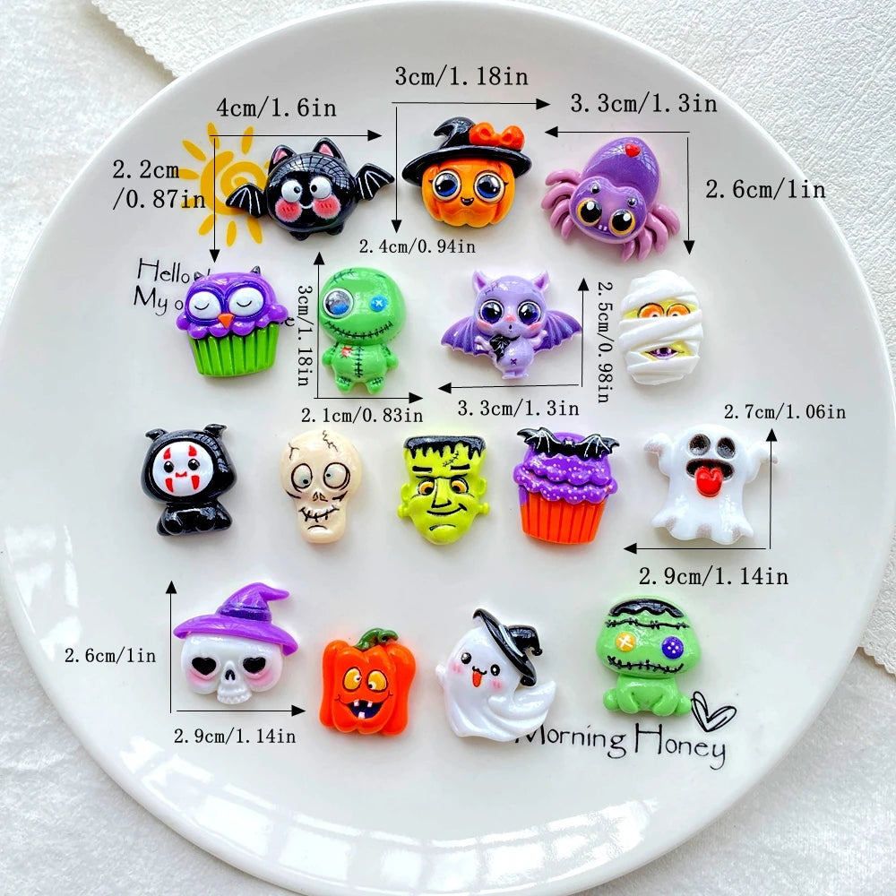 A white plate displays various Halloween resin charms including cats, bats, ghosts, and pumpkins.
