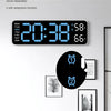 A digital alarm clock display showing the time 20:38, date, and temperature 66 degrees on a white wall.