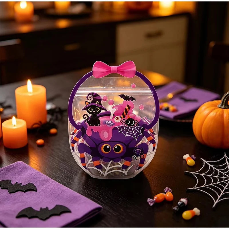 A clear bag filled with Halloween witch and bat themed treats sits on a dark table next to a pumpkin and candles.