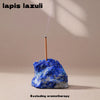 A piece of lapis lazuli stone with a wooden stick and a small flame, used as an aromatherapy holder.