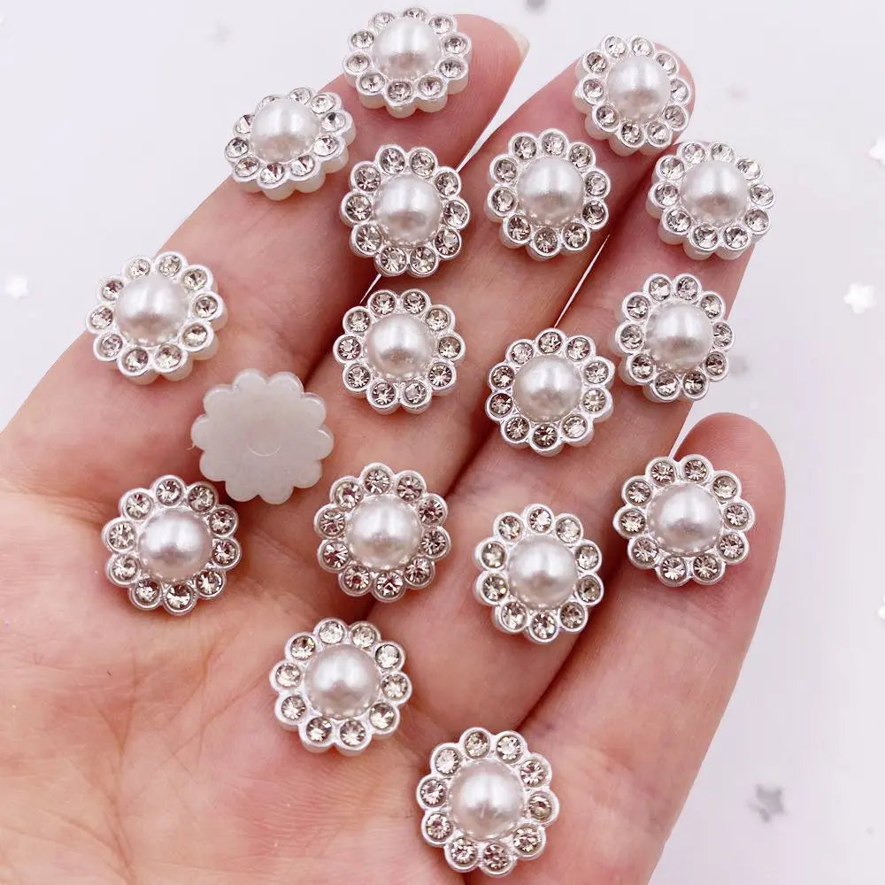A hand holds a collection of 50 pearl rhinestone flatback crystals for DIY crafts and decor.